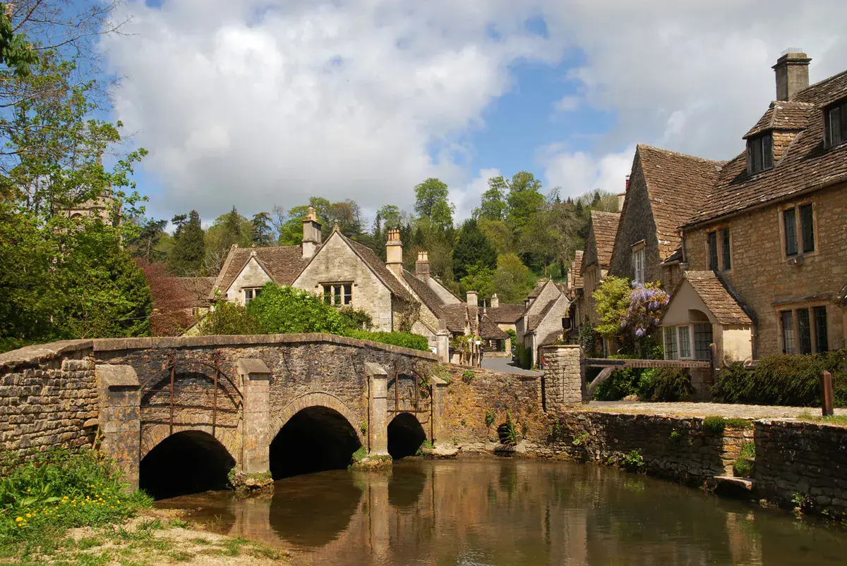 Puente de piedra sobre el arroyo y casas de Castle Combe, Wiltshire.