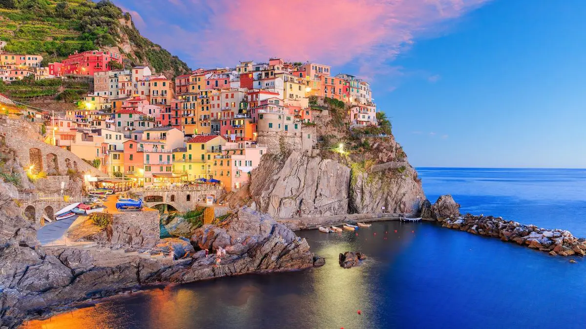 Casas de colores y promontorio rocoso de Manarola sobre el mar de Liguria.