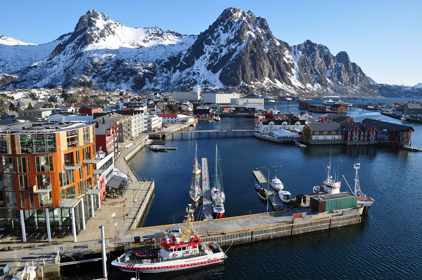 Svolvær, Noruega, con puerto, edificios costeros y montañas de Lofoten.