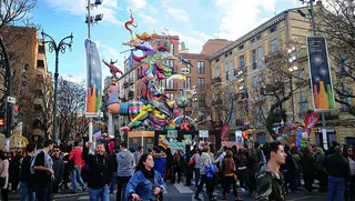 Falla monumental y visitantes en una calle de Valencia