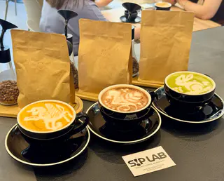 Cafés con latte art en la barra de Sip Lab